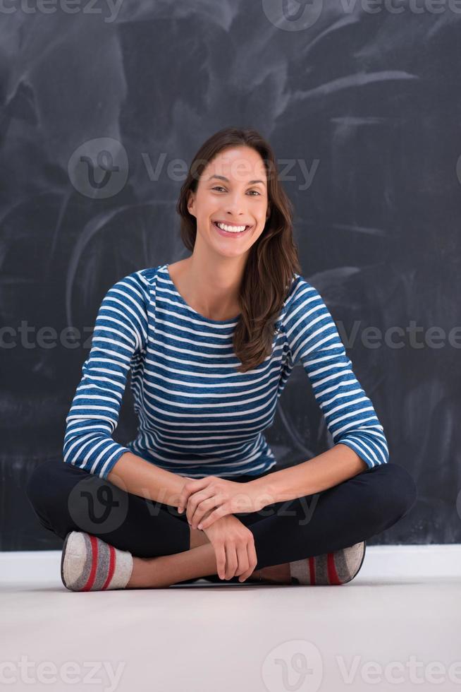 woman sitting in front of chalk drawing board photo