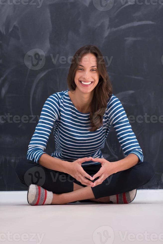 woman sitting in front of chalk drawing board photo