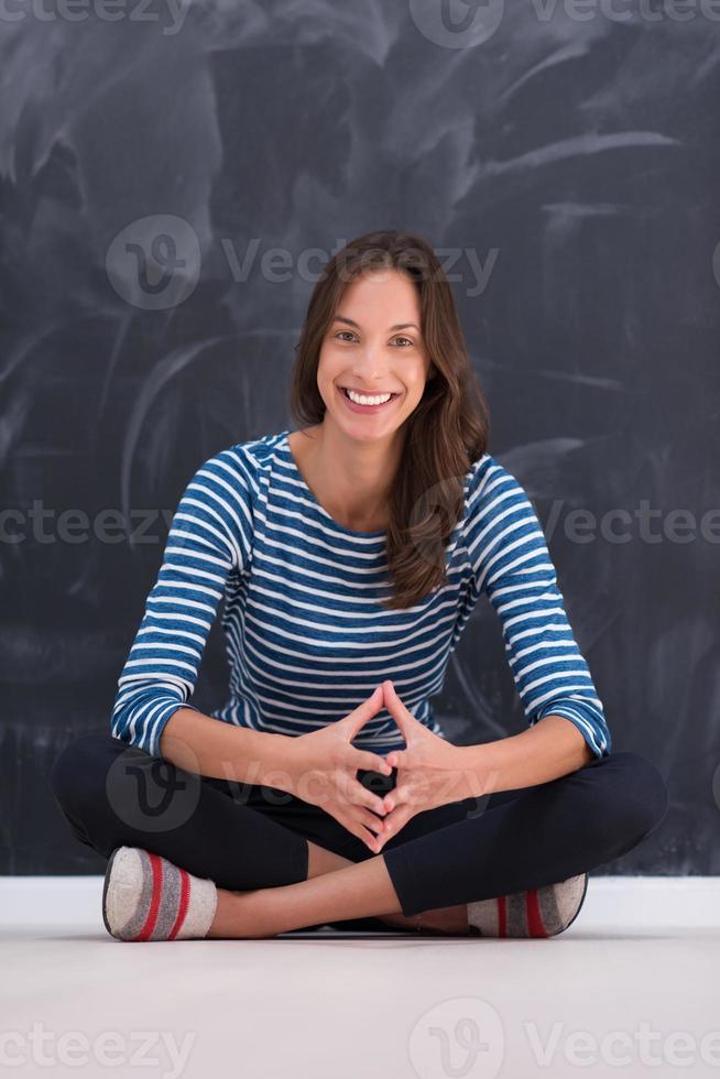 woman sitting in front of chalk drawing board photo