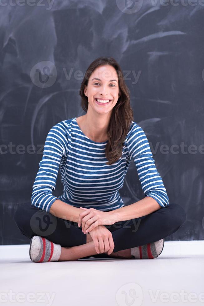 woman sitting in front of chalk drawing board photo