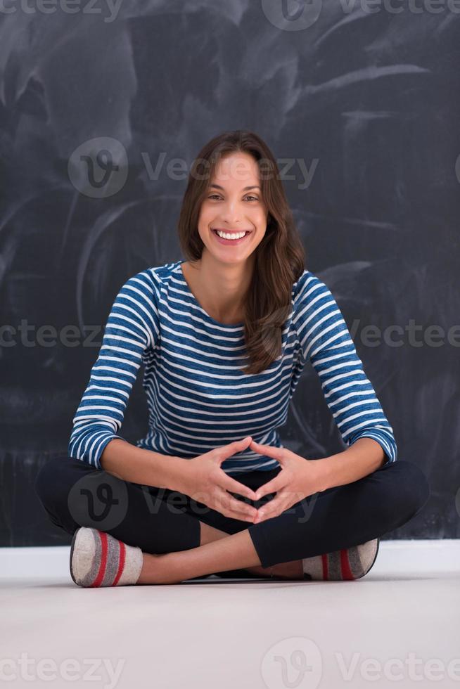 woman sitting in front of chalk drawing board photo