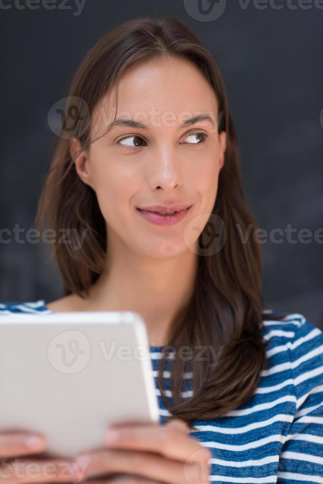 woman using tablet  in front of chalk drawing board photo