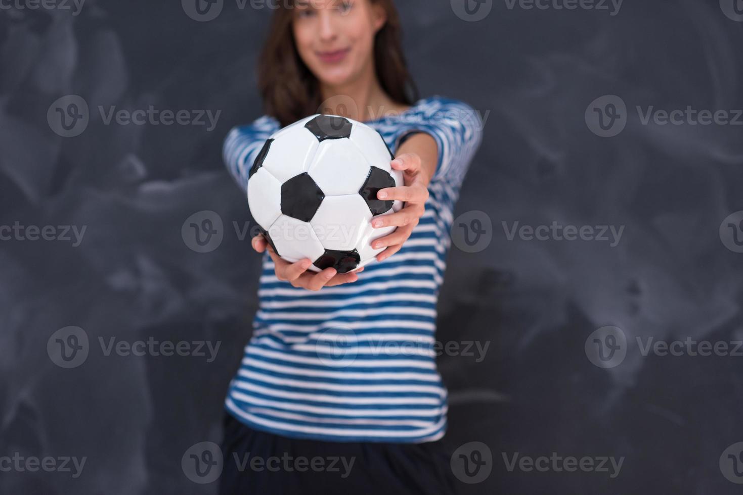 woman holding a soccer ball in front of chalk drawing board photo