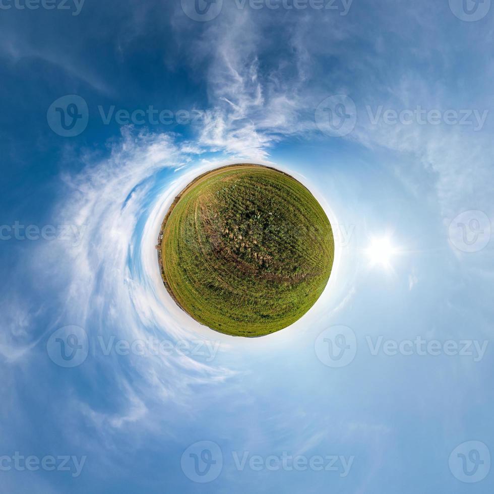 Little planet transformation of spherical panorama 360 degrees. Spherical abstract aerial view in field with awesome beautiful clouds. Curvature of space. photo