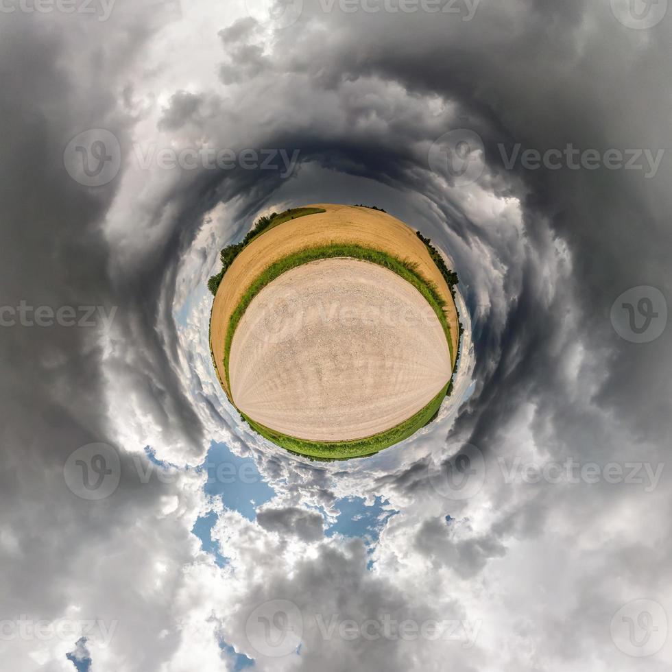 Little planet transformation of spherical panorama 360 degrees. Spherical abstract aerial view in field in nice evening with awesome beautiful clouds. Curvature of space. photo