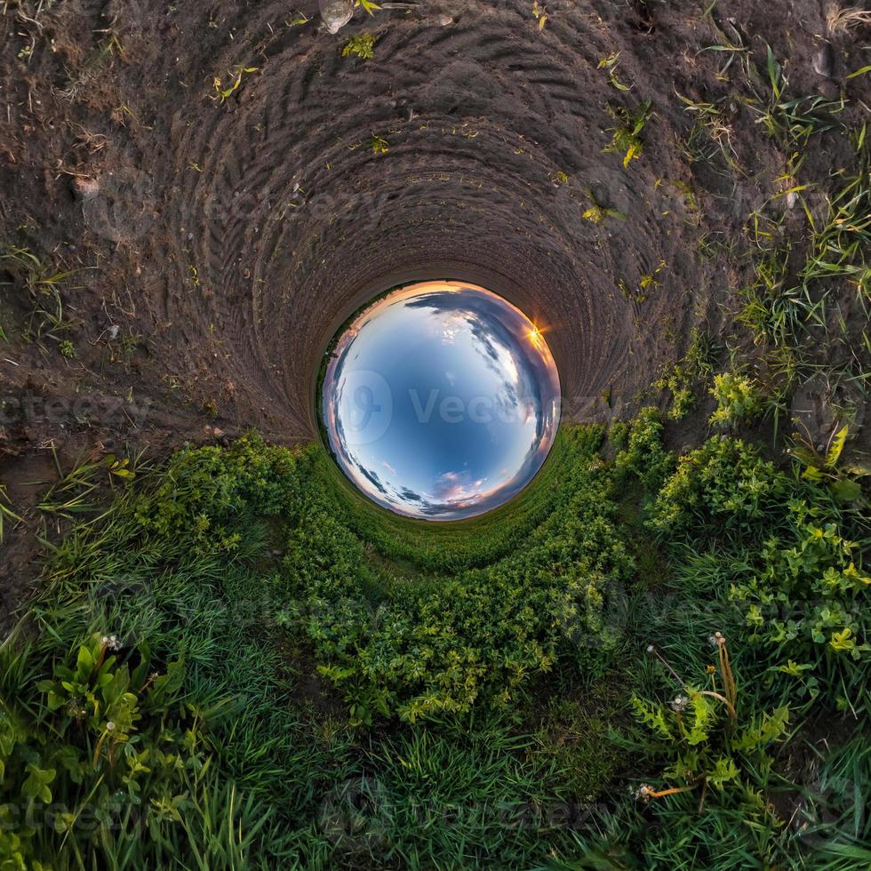 Inversion of little planet transformation of spherical panorama 360 degrees. Spherical abstract aerial view in field with awesome beautiful clouds. Curvature of space. photo