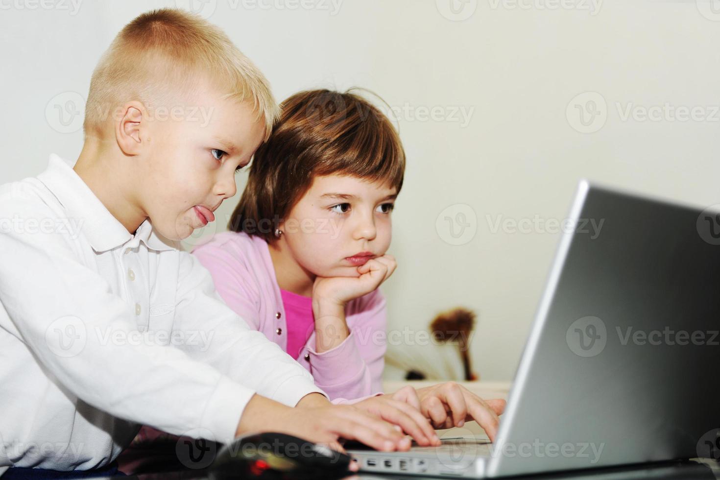 childrens have fun and playing games on laptop computer photo