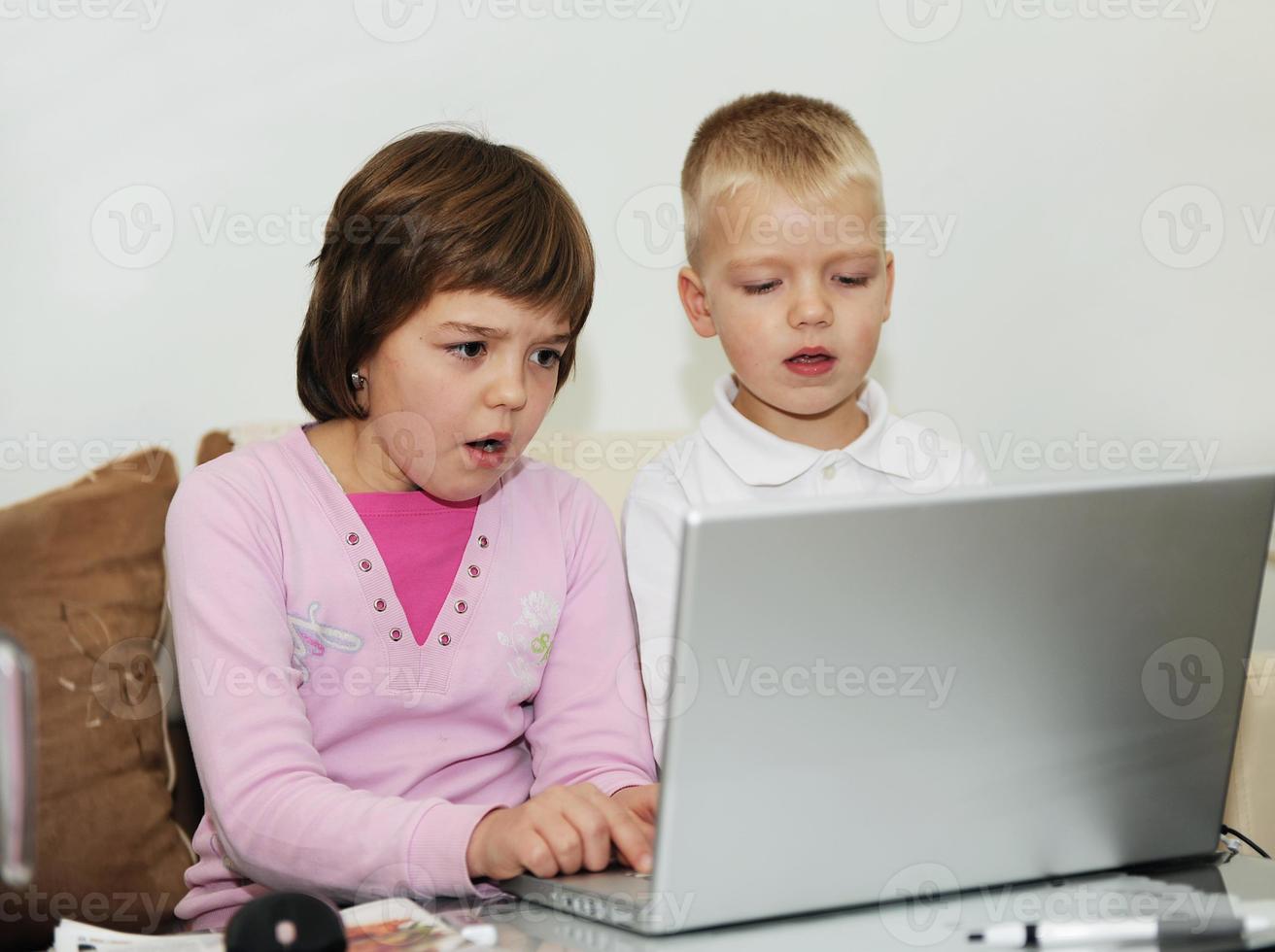 childrens have fun and playing games on laptop computer photo