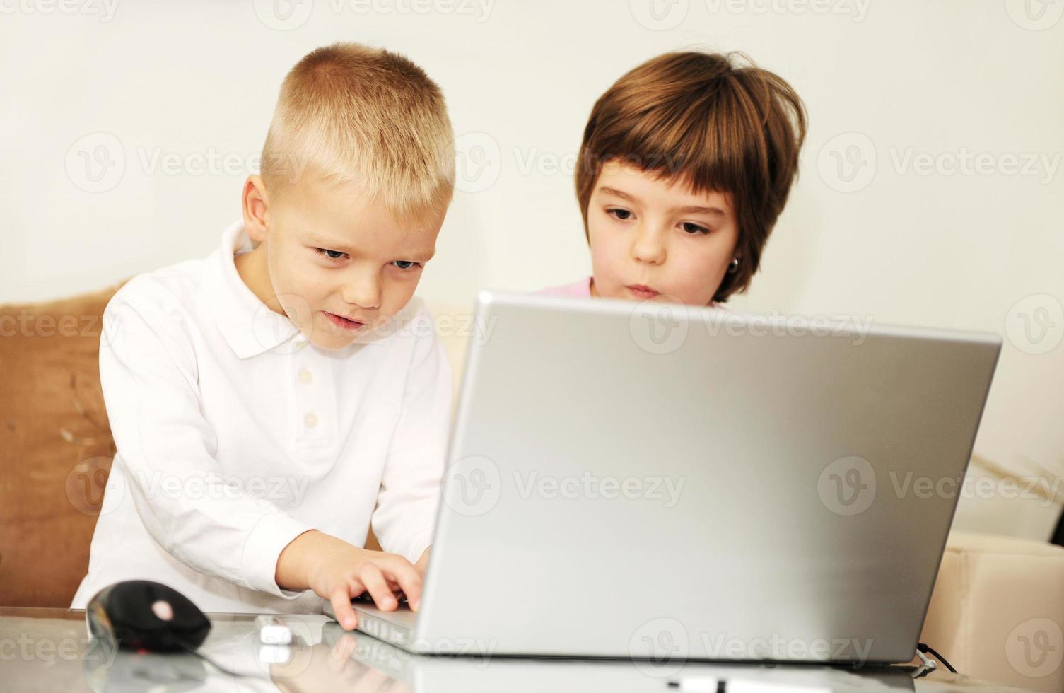 childrens have fun and playing games on laptop computer photo