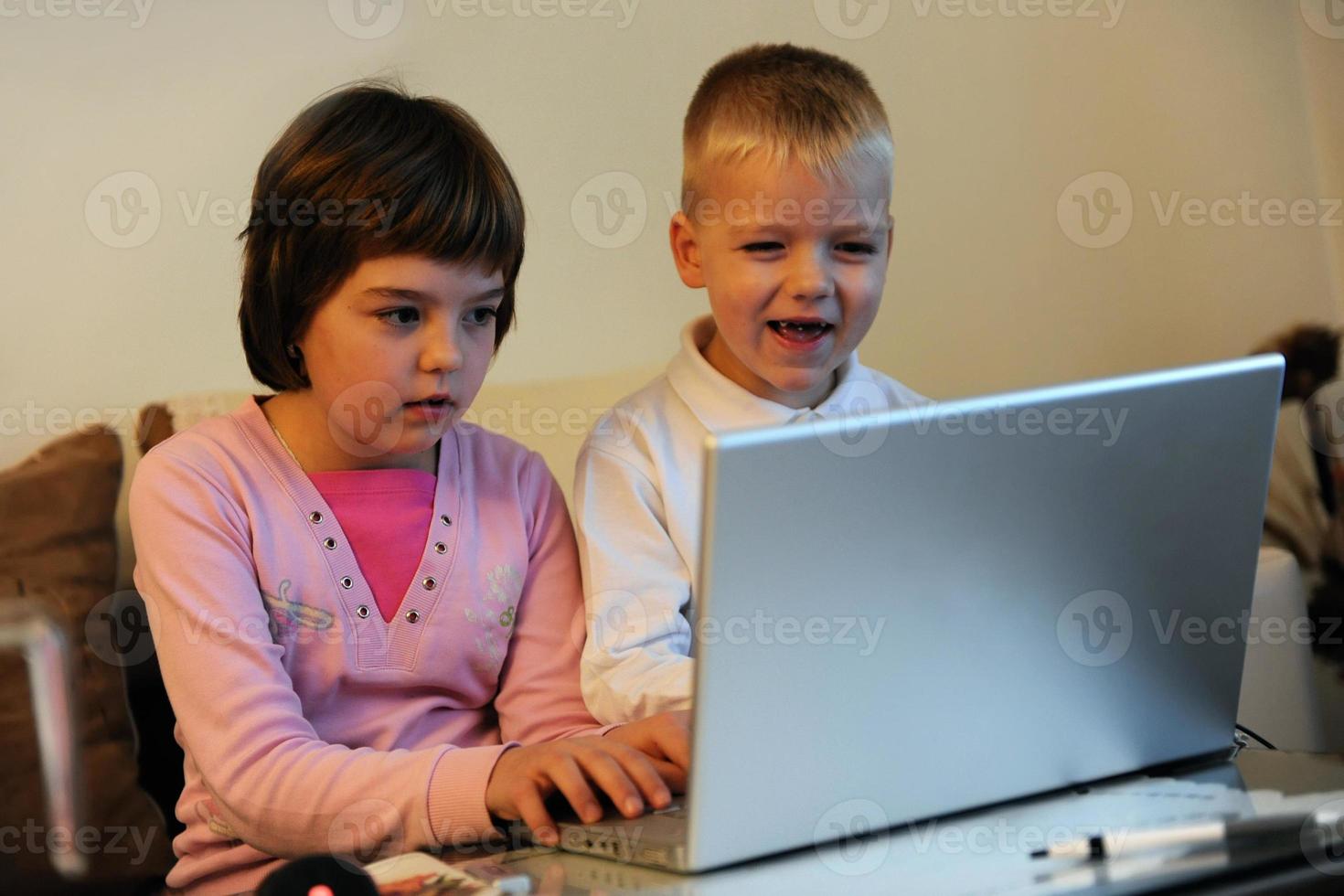 childrens have fun and playing games on laptop computer photo