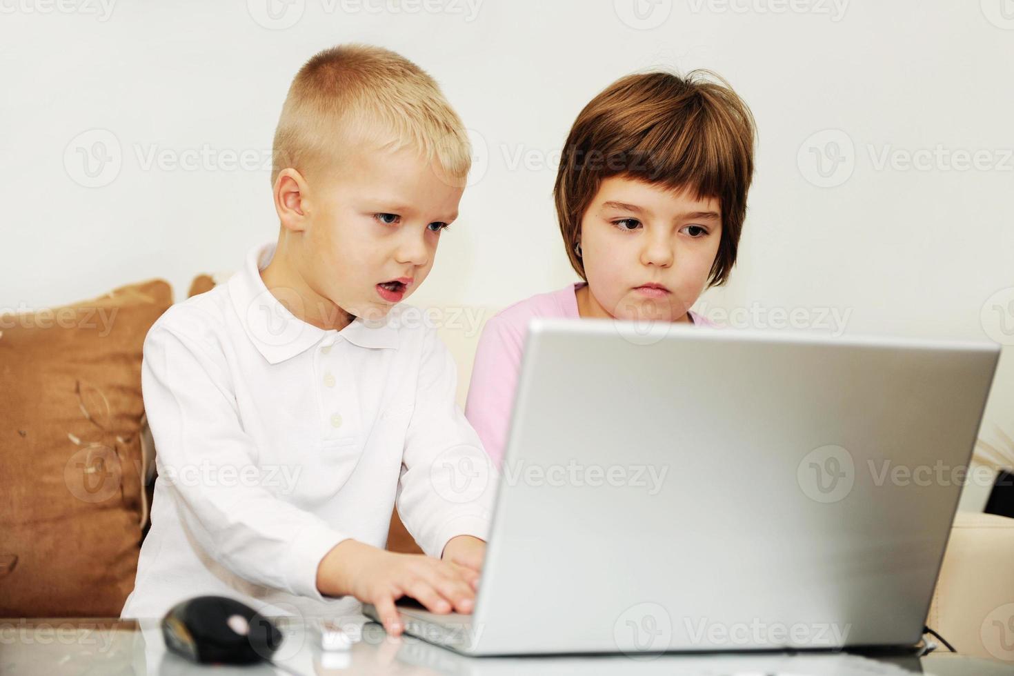 childrens have fun and playing games on laptop computer photo