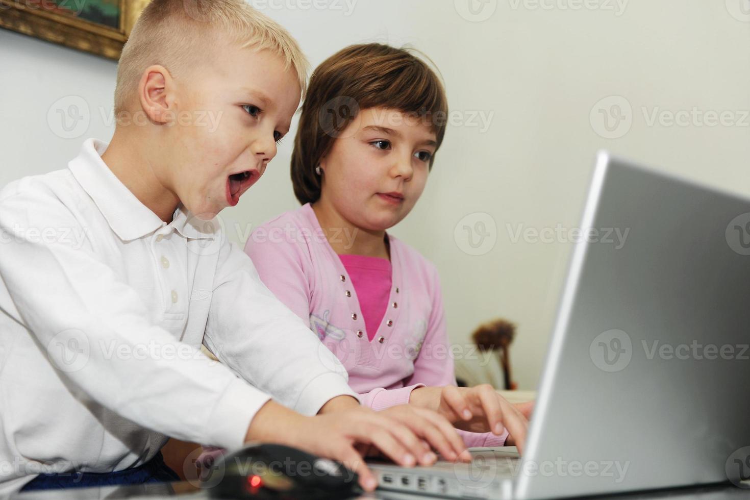 childrens have fun and playing games on laptop computer photo