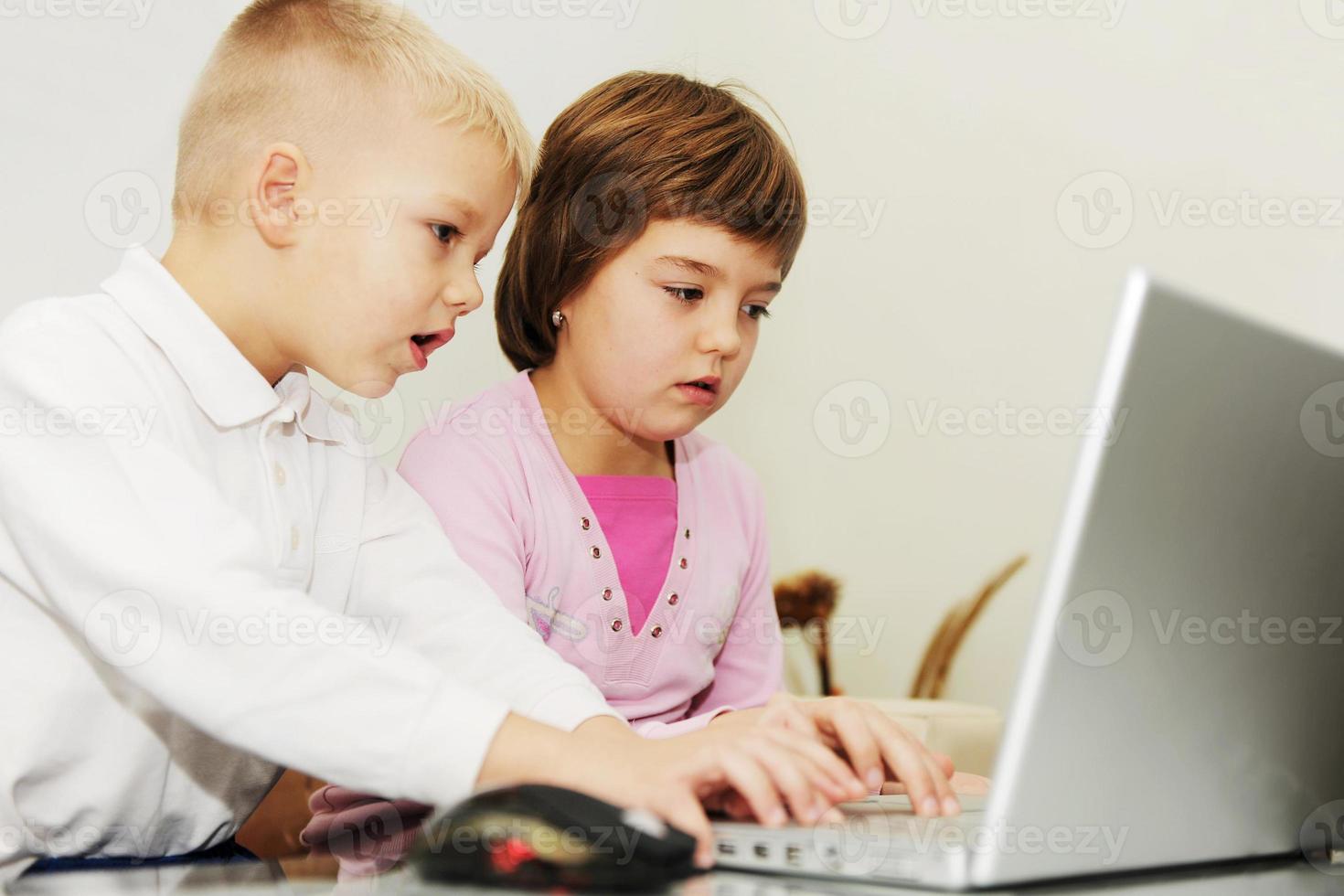 childrens have fun and playing games on laptop computer photo