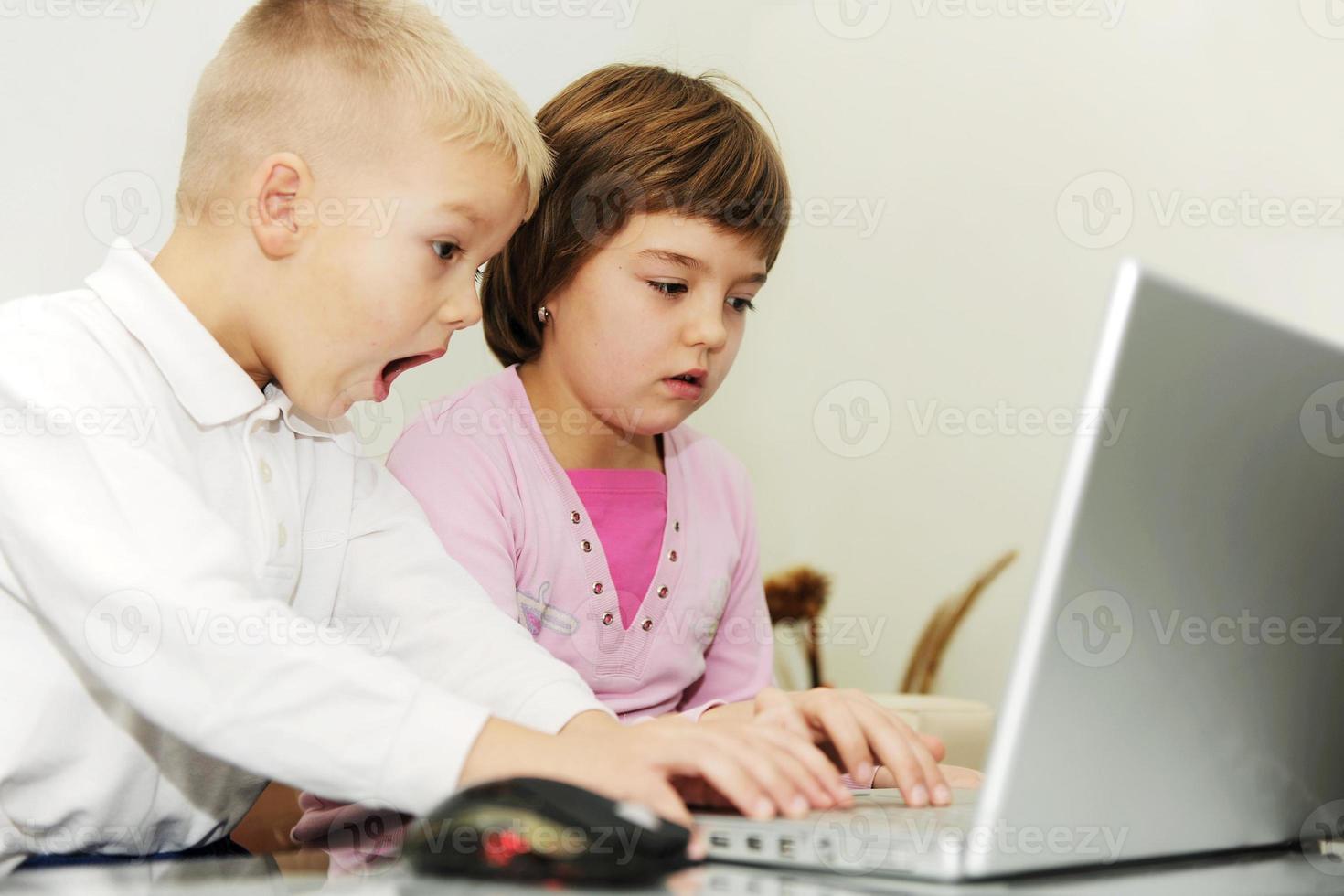 childrens have fun and playing games on laptop computer photo