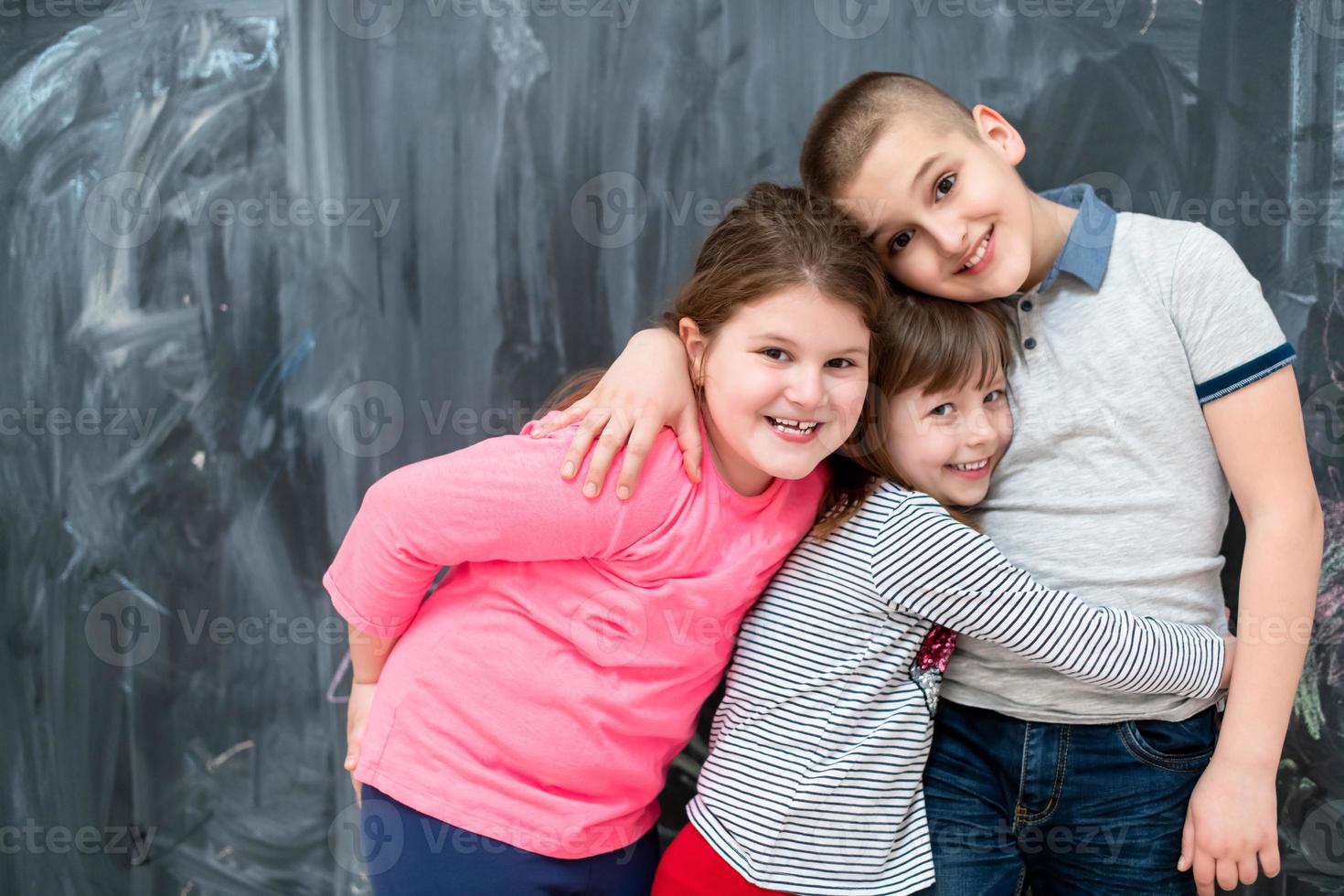 group of kids hugging in front of chalkboard photo