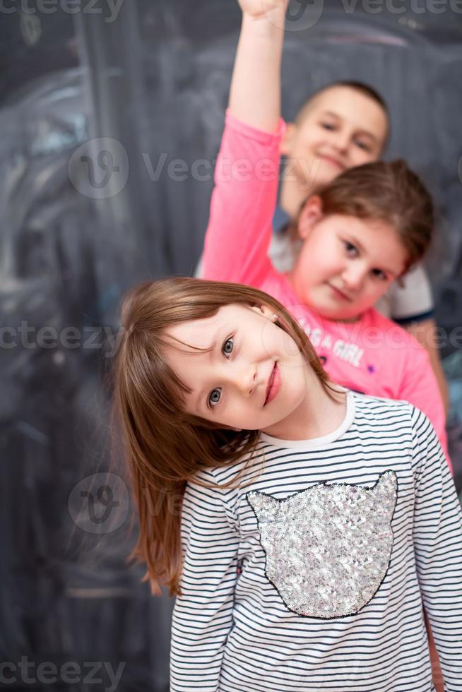 group of kids standing in front of chalkboard photo