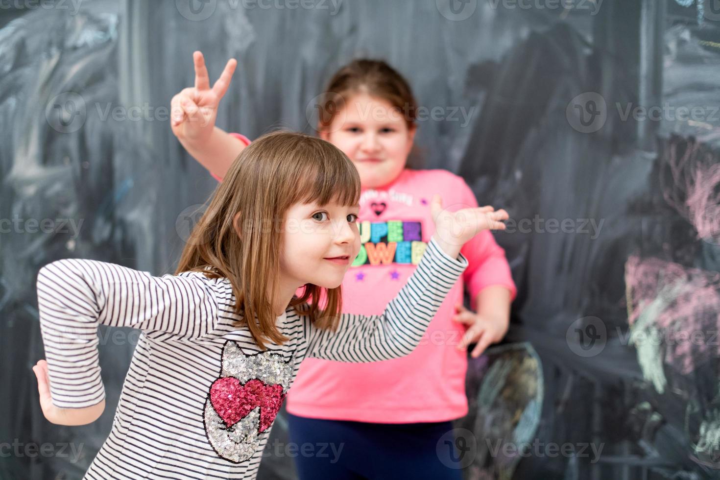 little girls having fun in front of chalkboard photo