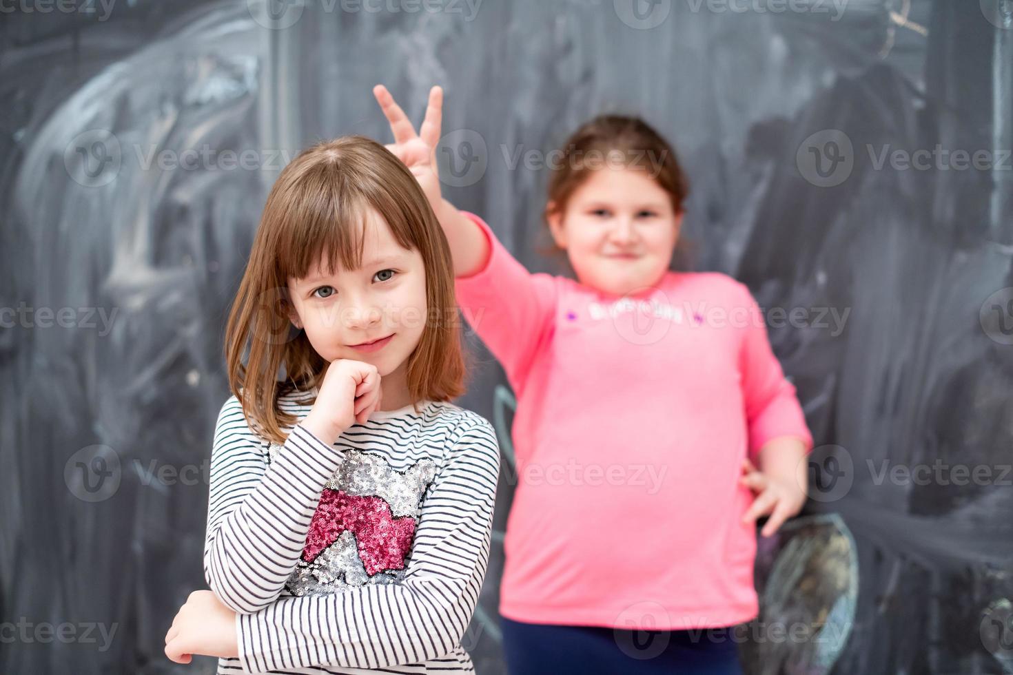 little girls having fun in front of chalkboard photo