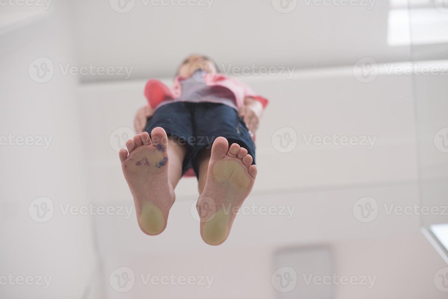 little boy standing on transparent glass floor photo
