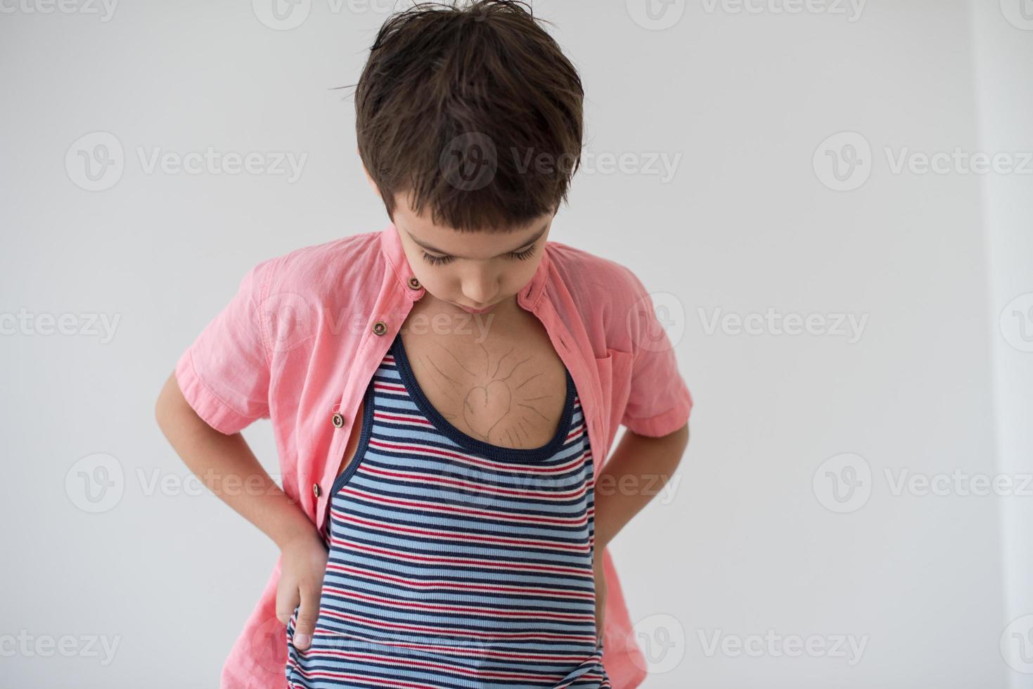 lilittle boy looking at heart love symbol sketched on his chest photo