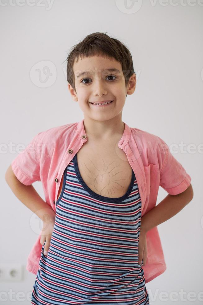 lilittle boy looking at heart love symbol sketched on his chest photo