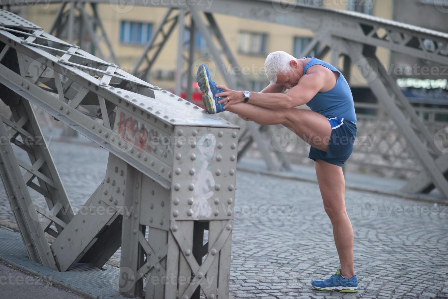 handsome man stretching before jogging photo