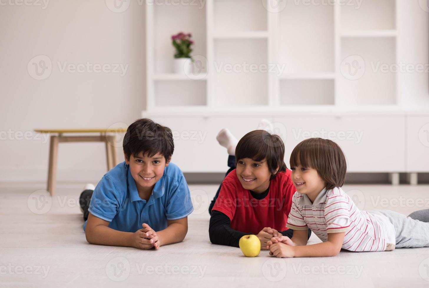 chicos divirtiéndose con una manzana en el suelo foto