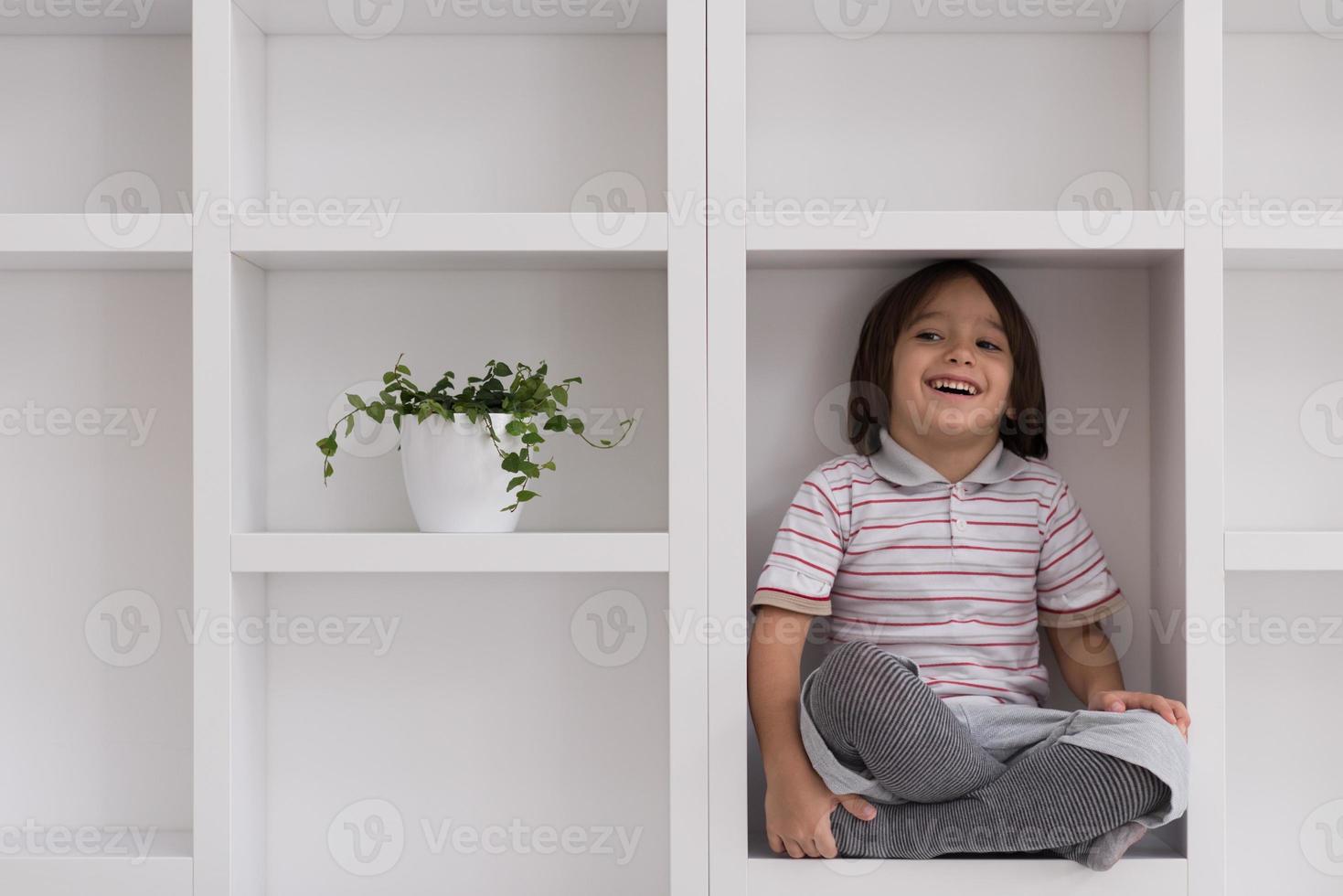 young boy posing on a shelf photo