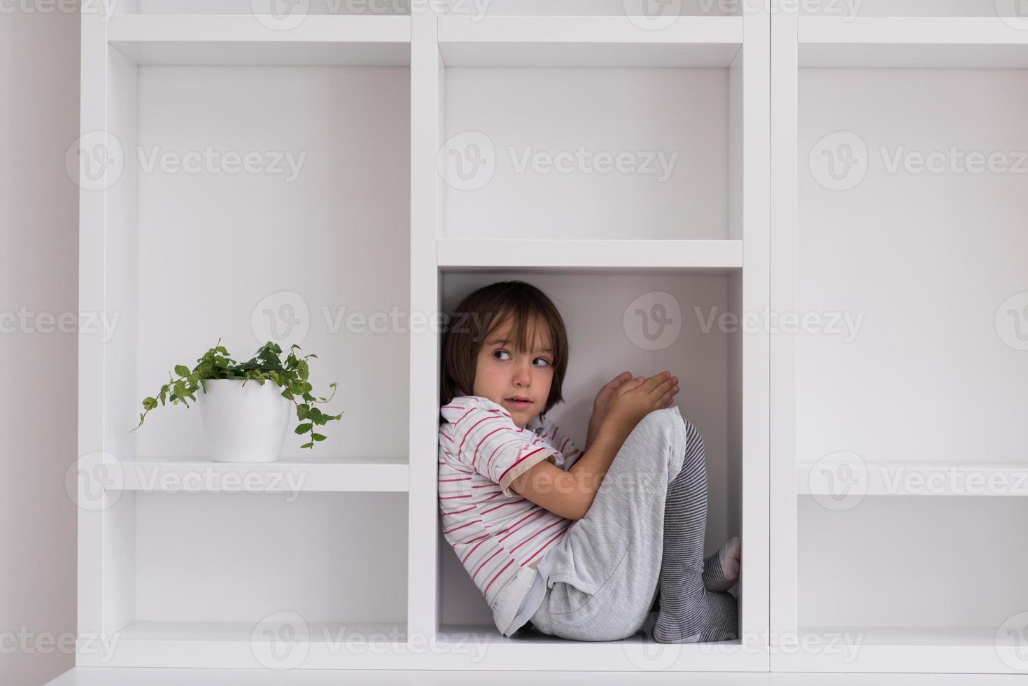 niño posando en un estante foto