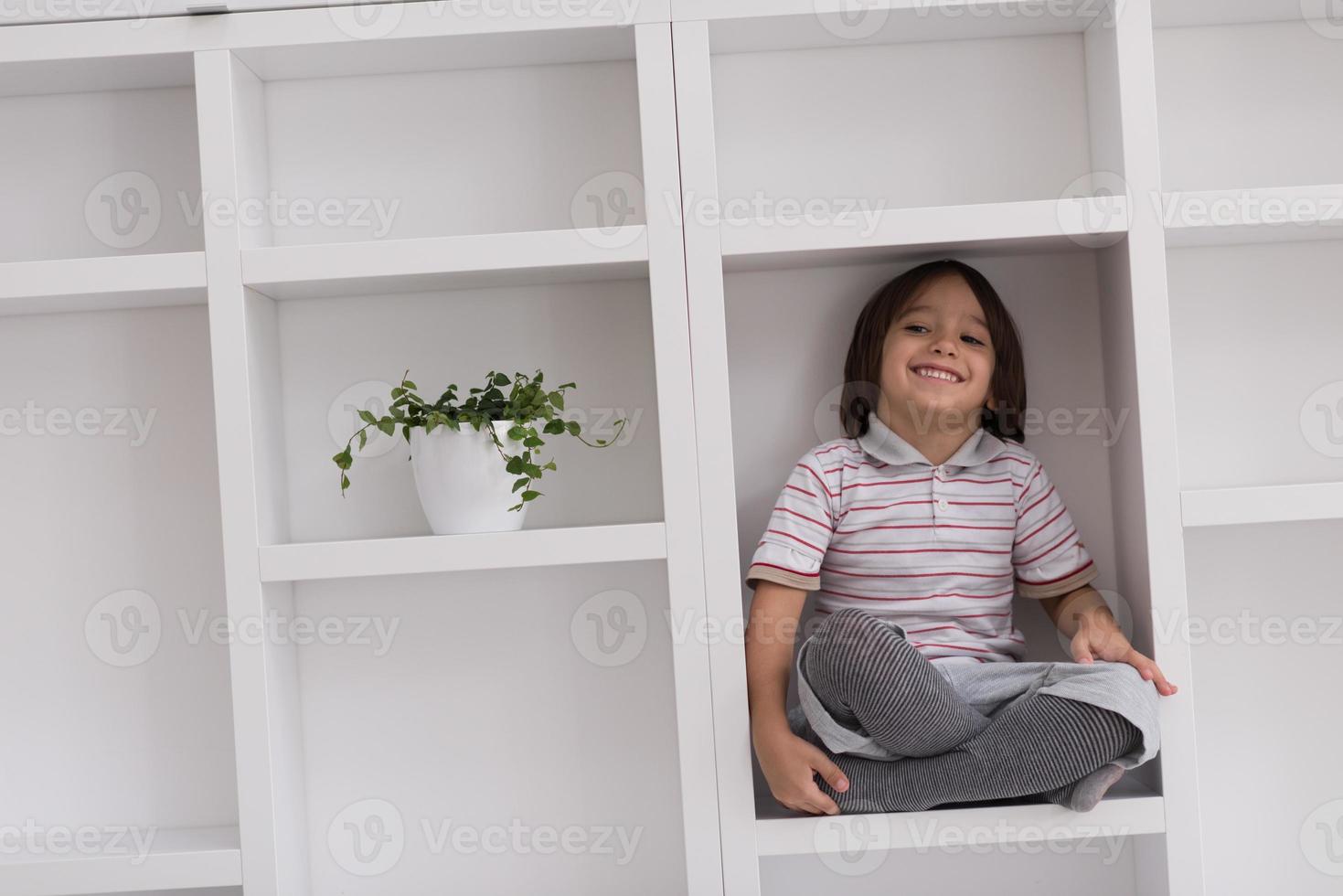 young boy posing on a shelf photo