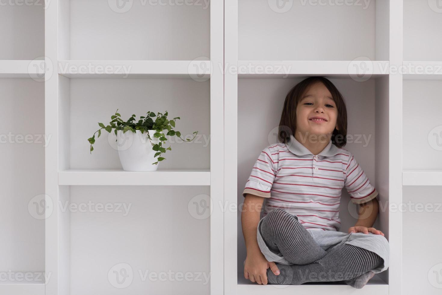 young boy posing on a shelf photo