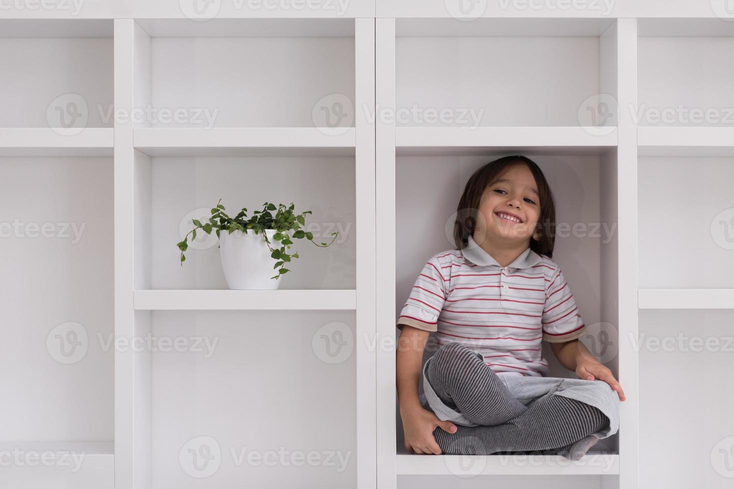 young boy posing on a shelf photo