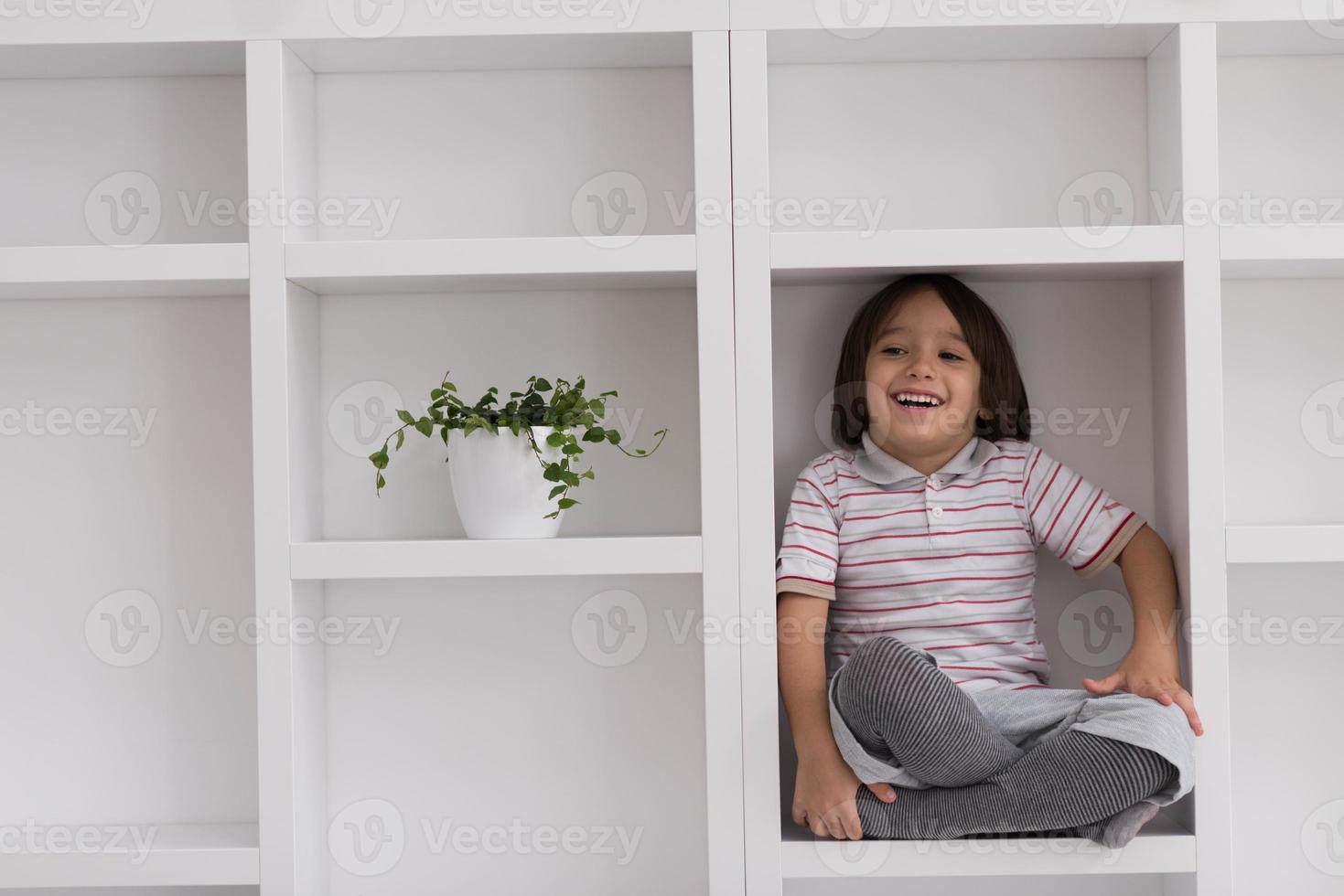 young boy posing on a shelf photo