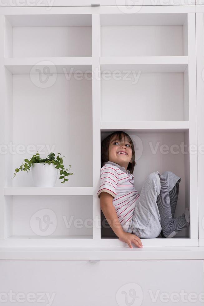 niño posando en un estante foto