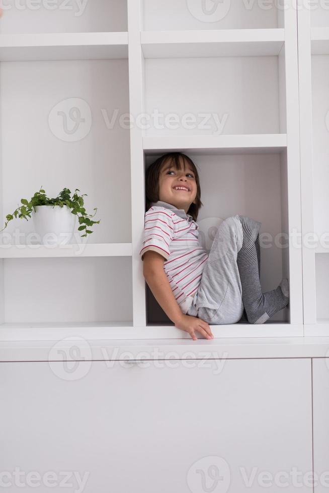 young boy posing on a shelf photo