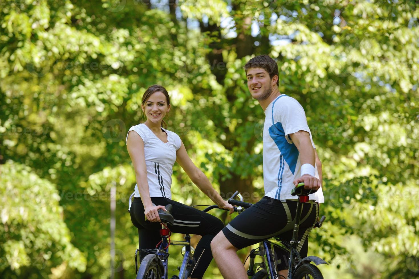 Happy couple riding bicycle outdoors photo