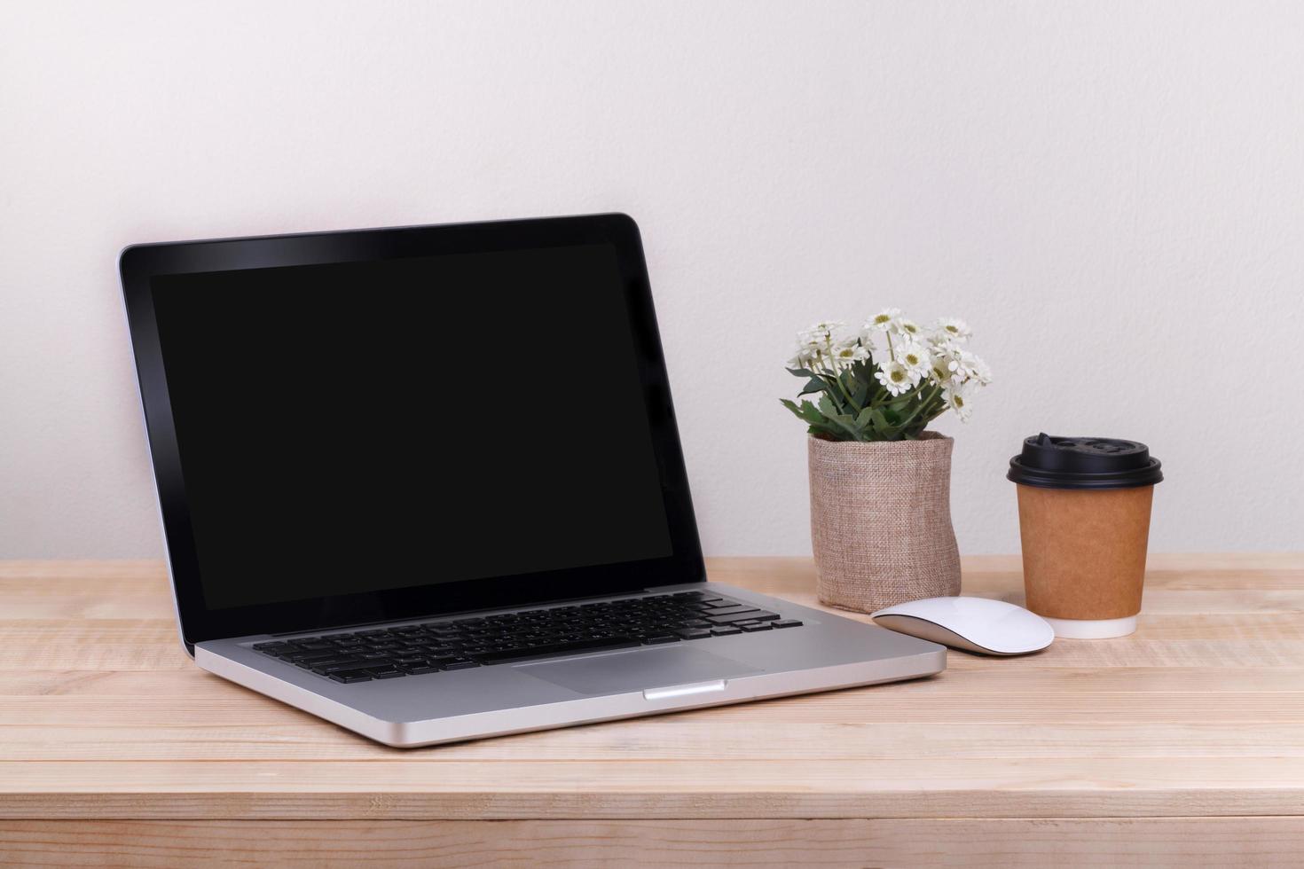 Front view of the laptop and coffee is on the work table concrete background photo