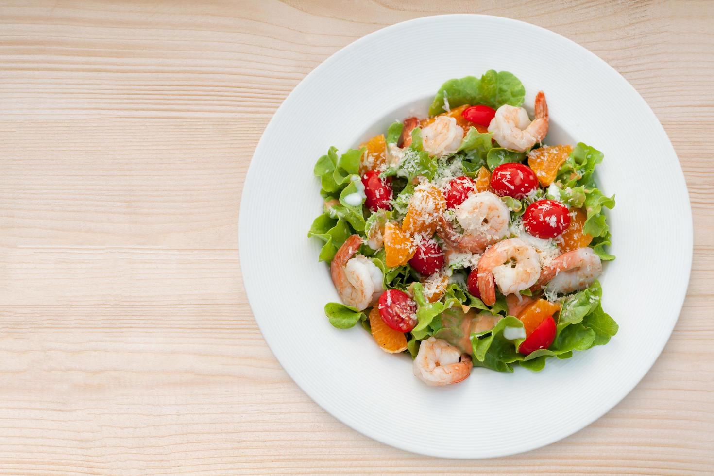 Grilled shrimp salad on wood table, Top view photo