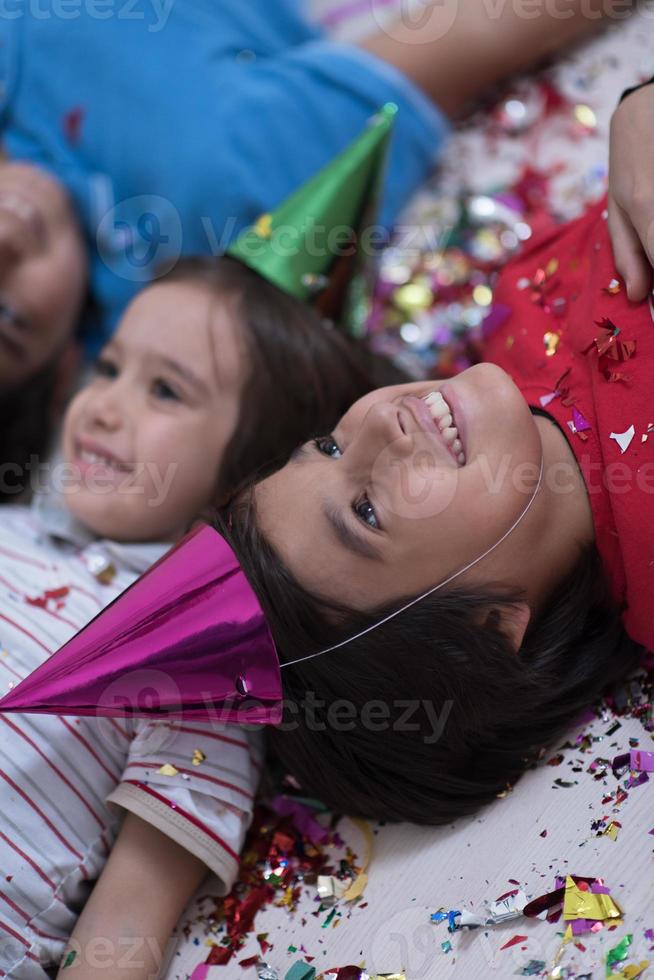 kids  blowing confetti while lying on the floor photo