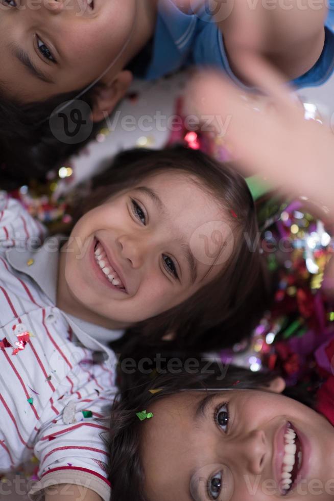 kids  blowing confetti while lying on the floor photo