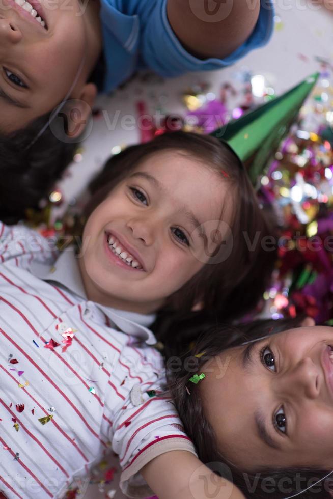 kids  blowing confetti while lying on the floor photo