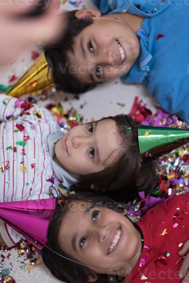 kids  blowing confetti while lying on the floor photo