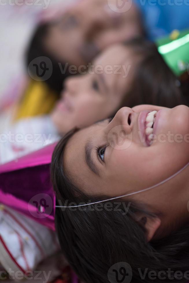 kids  blowing confetti while lying on the floor photo