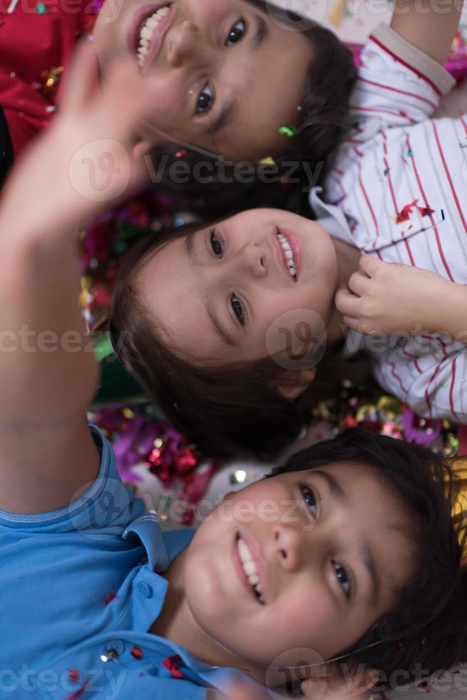 kids  blowing confetti while lying on the floor photo