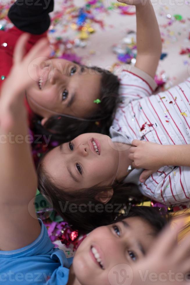 kids  blowing confetti while lying on the floor photo