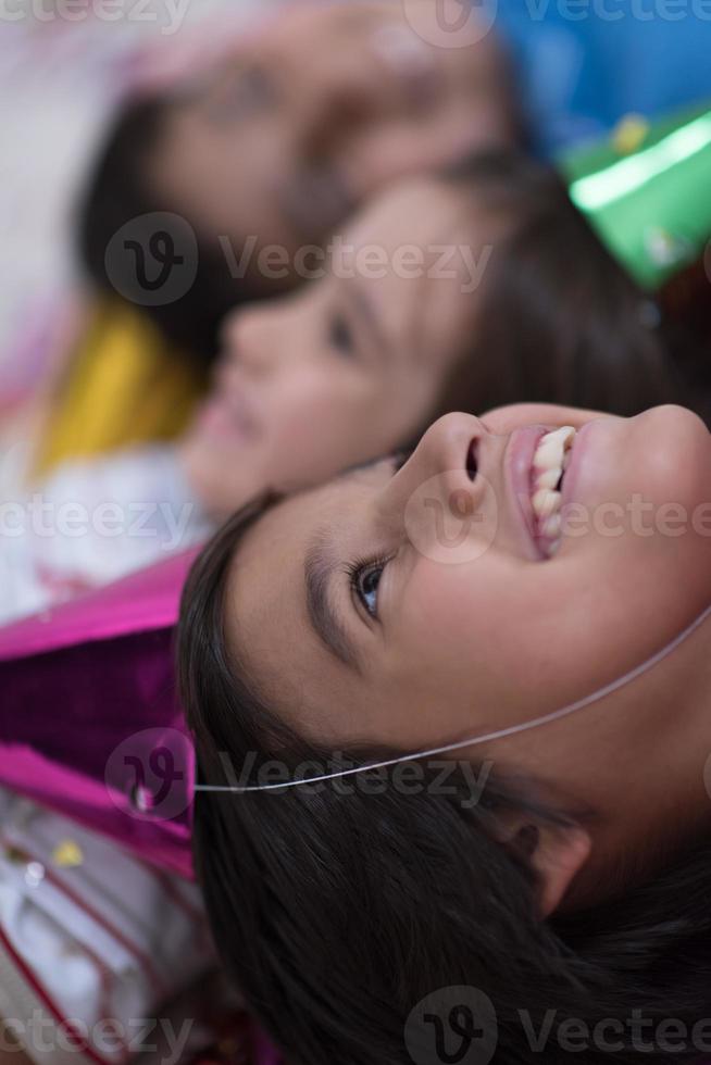 kids  blowing confetti while lying on the floor photo