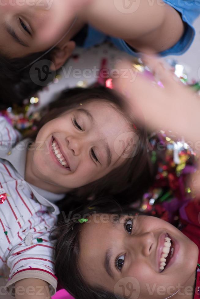 kids  blowing confetti while lying on the floor photo