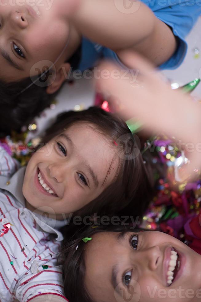 kids  blowing confetti while lying on the floor photo