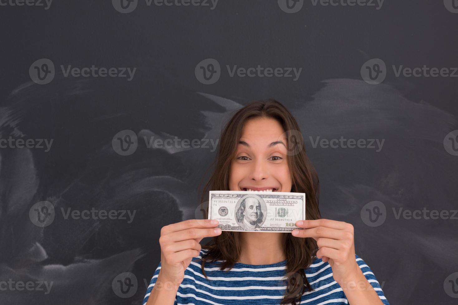 mujer sosteniendo un billete frente a un tablero de dibujo de tiza foto