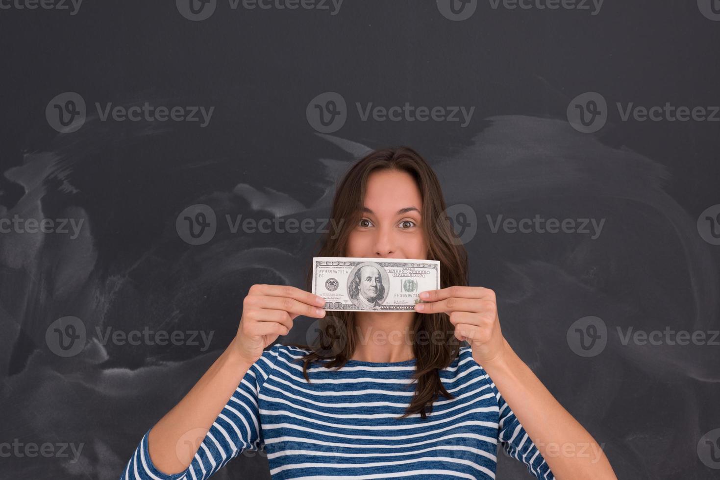 mujer sosteniendo un billete frente a un tablero de dibujo de tiza foto